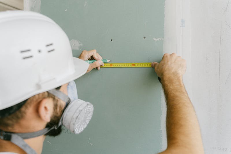 Contractor measuring drywall