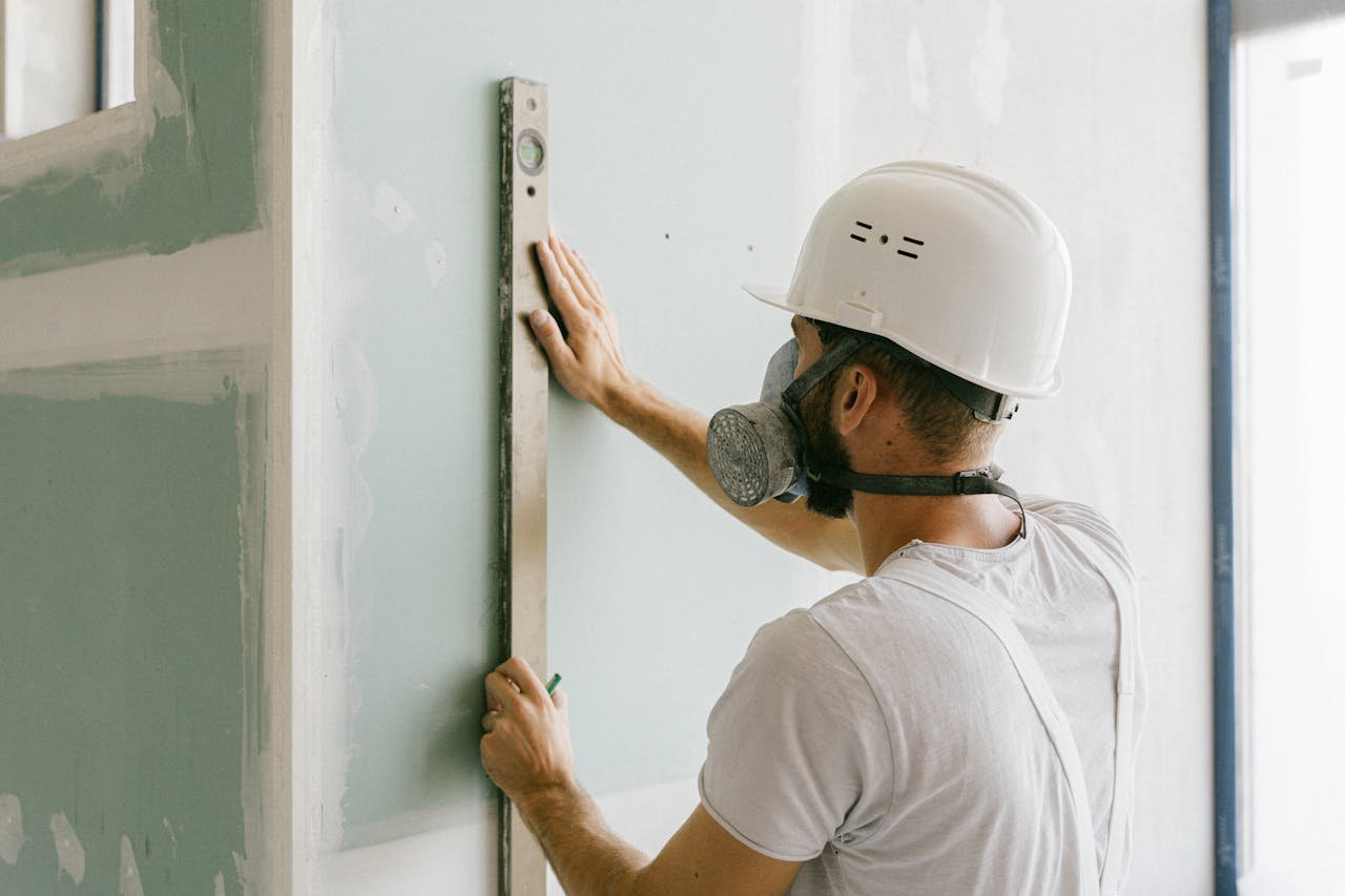 Professional drywall contractor using a leveler